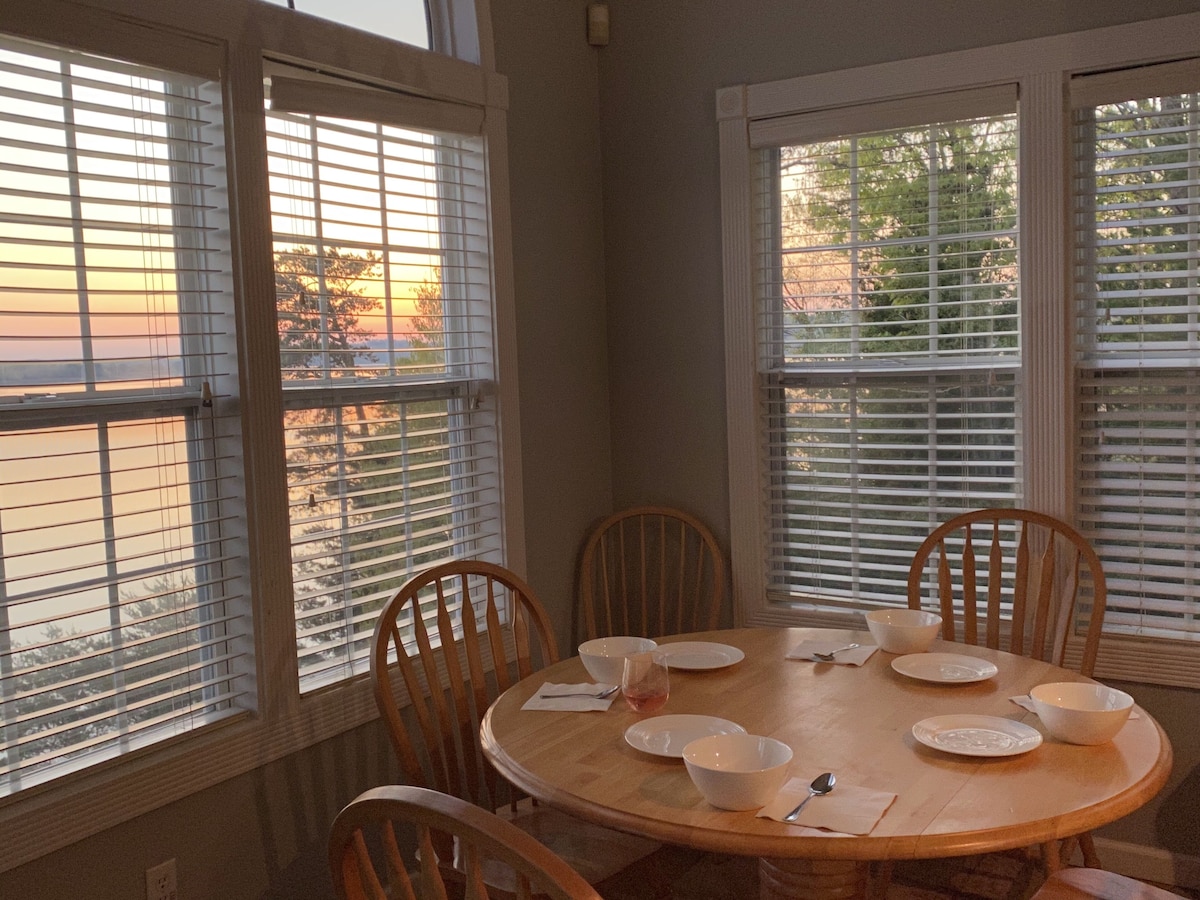 Round dining table set beside windows in warm evening light