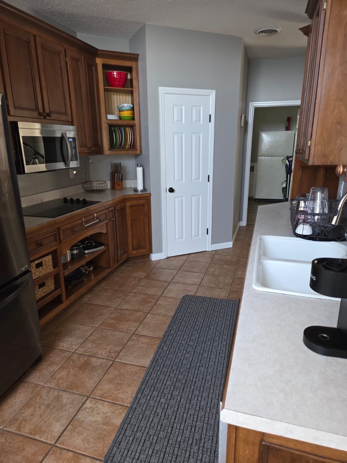 Main kitchen with cooktop, microwave, sink and cookware
