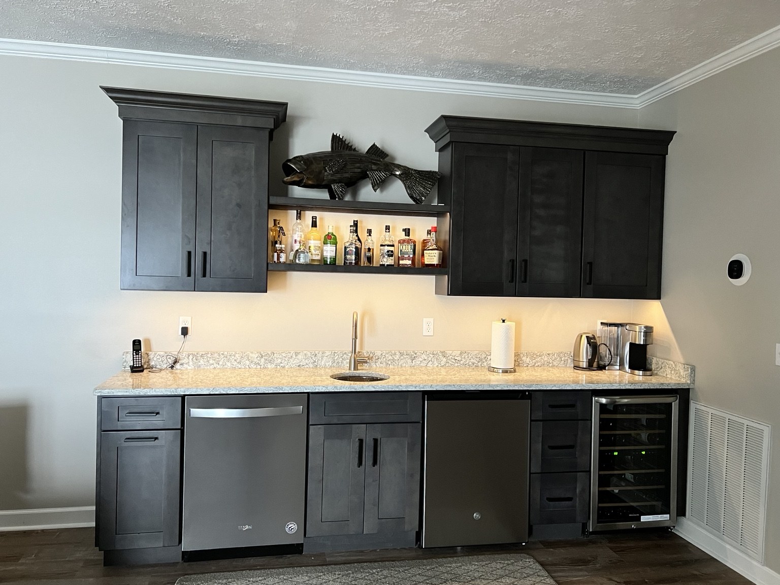 Downstairs wet bar with cabinetry, sink, dishwasher and fridge